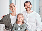 Portrait of happy caucasian couple sitting at home with their daughter. Adorable little girl smiling while sitting at home with her parents. Happy family is a happy childhood 