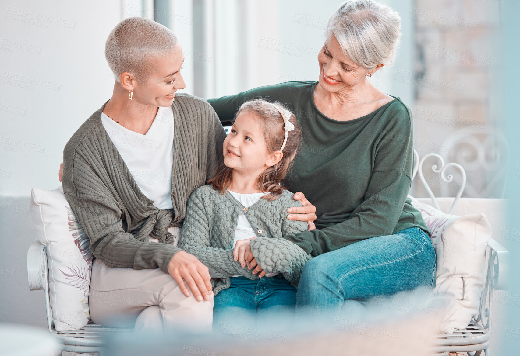 Buy stock photo Mother, grandmother and girl with talk, sofa and hug for care, bonding or love in family home lounge. Elderly lady, kid and mom for embrace with smile, relax or together on living room couch in house
