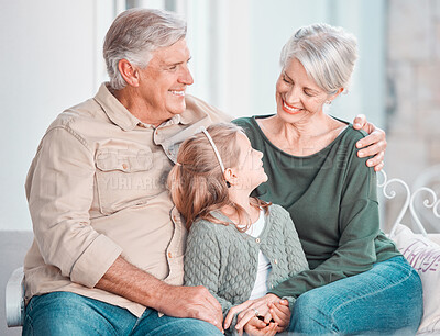 Buy stock photo Grandparents, child and happy on couch, hug or memory with care, bonding or love in home living room. Old man, elderly woman and girl with embrace on lounge sofa, relax and talking in family house