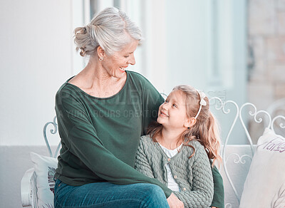 Buy stock photo Grandmother, girl child and smile on sofa with hug, care or bonding for love, talk and family home lounge. Elderly lady, child and embrace with smile, relax and together on living room couch in house