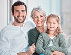 Portrait of three family members looking and smiling at the camera. Adorable little girl bonding with her grandmother and father at home
