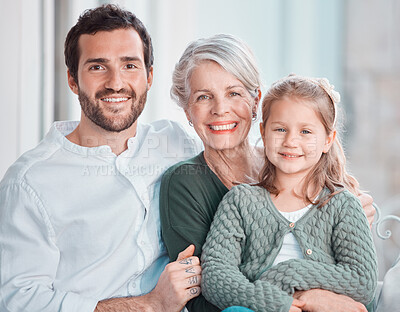 Portrait of three family members looking and smiling at the camera. Adorable little girl bonding with her grandmother and father at home