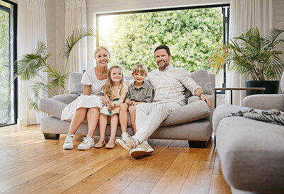 Fullbody young smiling caucasian family sitting on the couch together and bonding in a home lounge on a weekend. Mother and father sitting with children on a sofa