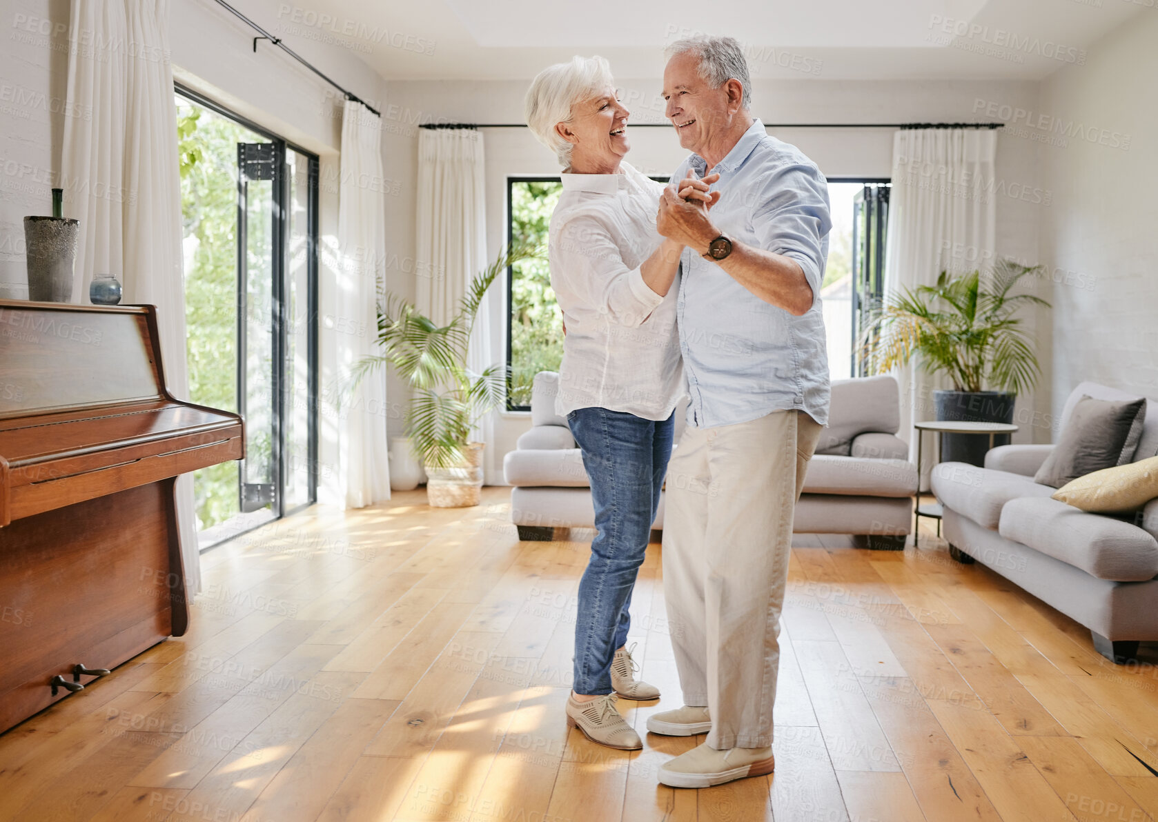 Buy stock photo Love, dance and a senior couple in the living room of their home together for retirement bonding. Smile, trust or holding hands with an elderly man and woman moving in their apartment for romance