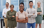Portrait of a group of happy diverse businesspeople standing together with their arms crossed and smiling standing outside. Confident work colleagues standing together looking positive