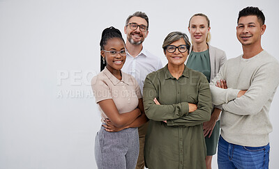 Buy stock photo Portrait of a group of a multiracial business team standing in a group in studio isolated against a grey background. Young and senior work colleagues standing together with their arms crossed