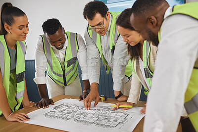 Buy stock photo Closeup of a happy diverse multiracial group of architect colleagues analyzing a blueprint design on a building and discussing plans for the next project. Team of young and senior designers working on a strategy for a building construction plan while wearing reflectors