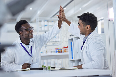 Buy stock photo Two happy , smiling and cheerful professional scientists celebrating success with a high five while working together in a lab. Mixed race man and black african american male wearing spectacles showing each other support and agreement smiling together and doing a hive five hand gesture