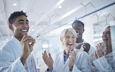 Diverse group of happy scientists clapping hands while writing and planning together on a board at work. Team of cheerful lab workers sharing ideas and brainstorming while standing together