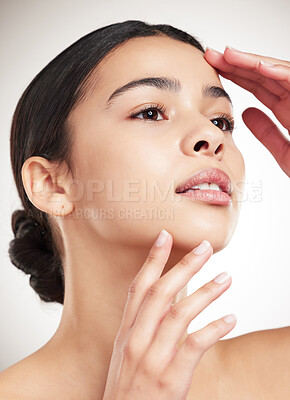 Buy stock photo Young mixed race beautiful woman touching her face against a grey studio background. Hispanic female showing her face posing against a background