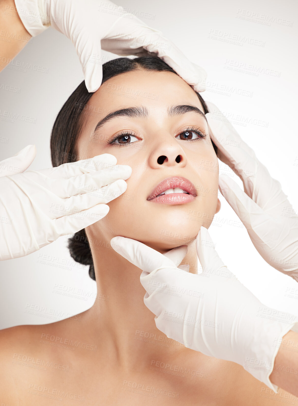 Buy stock photo Portrait of a young mixed race woman having her face examined against a grey studio background. Hispanic female taking care of her skin with a checkup against a background