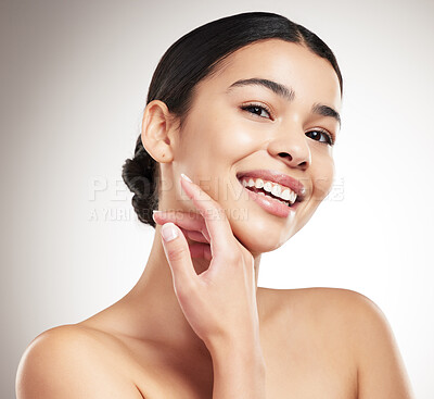 Buy stock photo Portrait of a young beautiful mixed race woman touching and feeling her face posing against a grey studio background. Confident hispanic female posing against a background