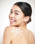 Young happy beautiful woman showing her applying cream on her shoulder posing against a grey studio background. Skincare is important. Protection from the sun