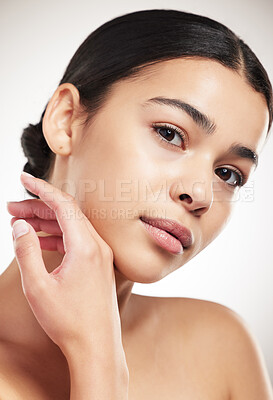 Buy stock photo Young beautiful mixed race woman touching and feeling her face posing against a grey studio background. Confident hispanic female posing against a background