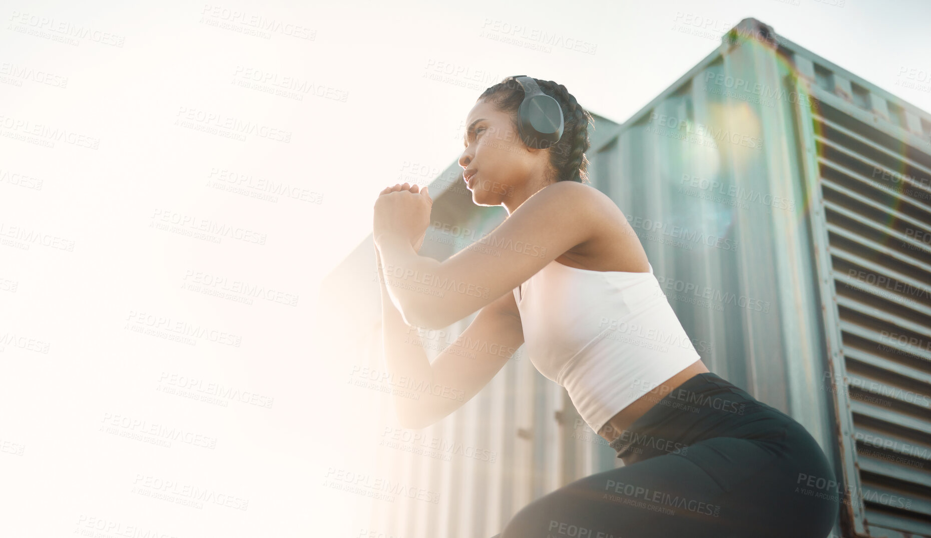 Buy stock photo Fitness, woman with headphones and training with lens flare for motivation. Exercise or workout, health wellness or cardio and young female athlete squat in sportswear for healthy lifestyle