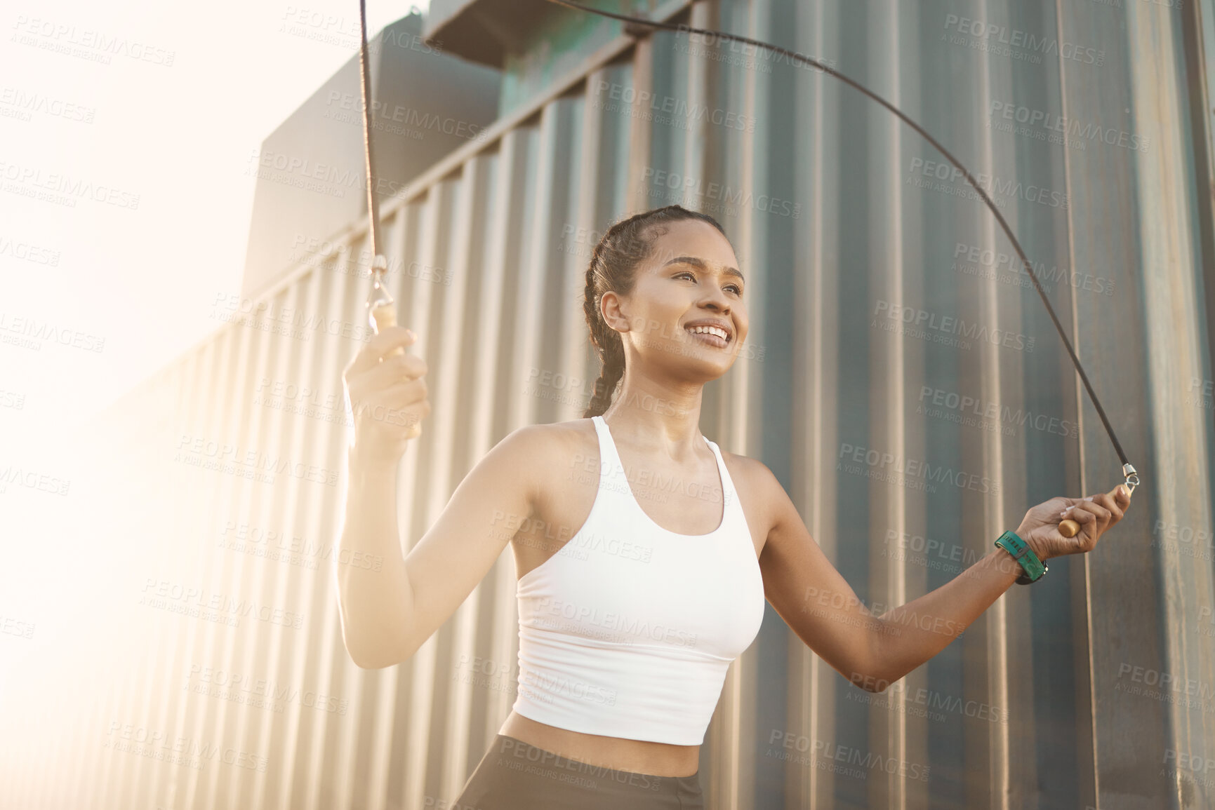 Buy stock photo City, jumping rope or happy woman in fitness training, workout or body exercise for cardio outdoors. Girl thinking, active or healthy female sports athlete skipping with smile for wellness in town