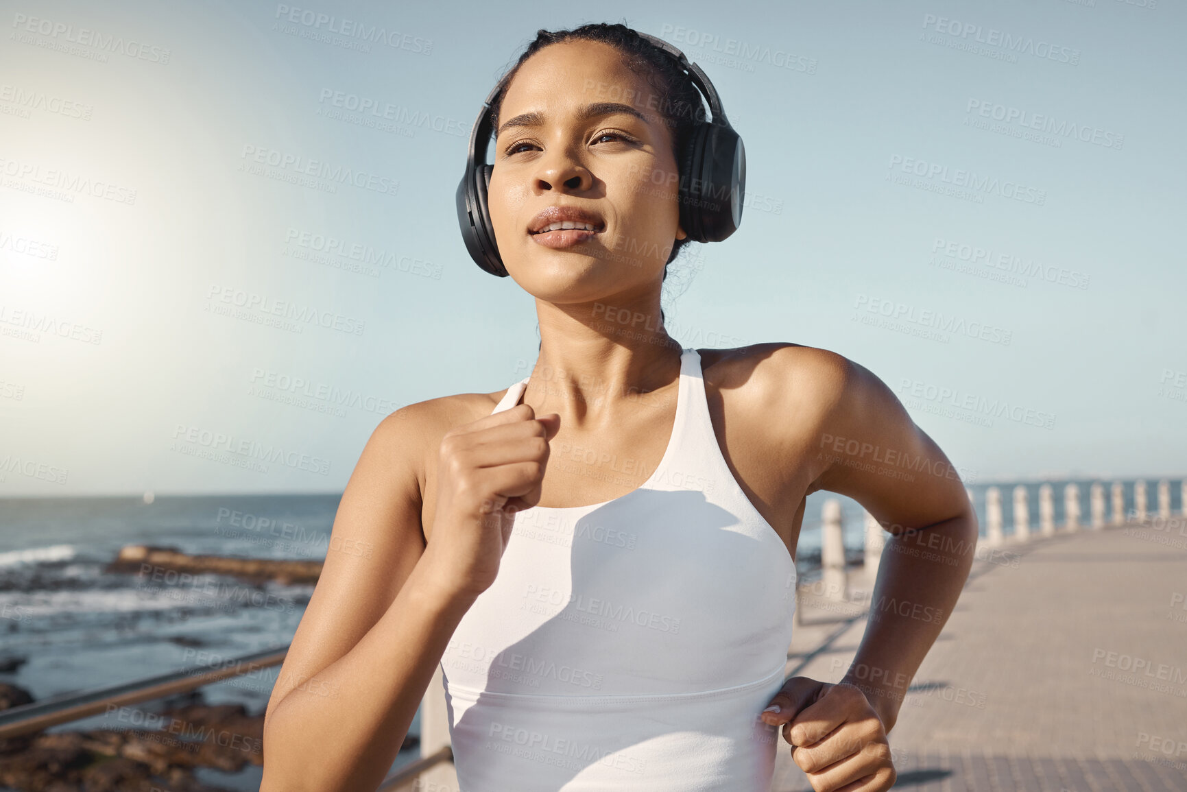 Buy stock photo Fitness, woman run at beach and with headphones listening to music for training. Exercise or marathon, lens flare or sportswear and female athlete running along the promenade listen to radio