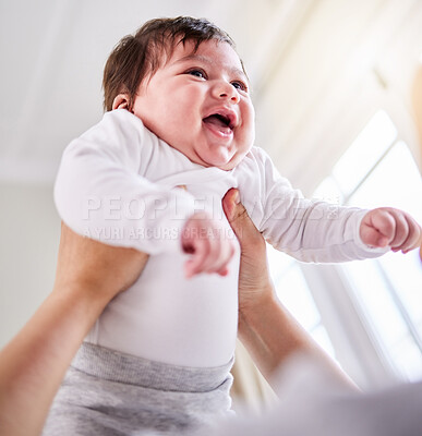 Shot of a mixed race adorable cute little baby laughing. Young mother playing with her newborn baby while laughing and enjoying bonding with her infant at home. Single mom happy on maternity leave