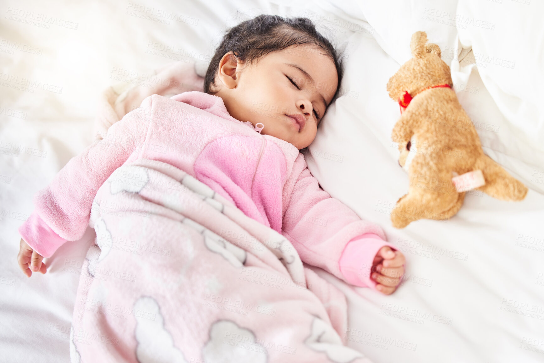 Buy stock photo Baby, sleeping and girl in bed with teddy bear, animal and peace in home with blanket and comfort. Child, rest and sleep in morning, nap and routine for health, wellness and calm face of infant