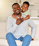 Portrait of an affectionate black man holding his child on a couch. African american father bonding with his son at home. Black single dad laughing and having fun with his happy boy on a sofa 