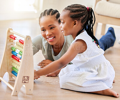 Buy stock photo Education, happy and black woman playing with kid on the floor in the living room at modern home. Abacus, mathematics and young African mother helping girl child with counting at house together.