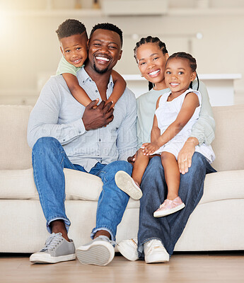 Portrait of a happy african american family with two children sitting on the couch at home. Adorable little girl and boy sitting with their mom and dad. Affectionate family of four bonding at home