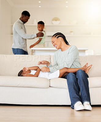 Buy stock photo Mother, child and tickle on couch, play and bonding together at home, fun and care in living room. Black family, daughter and love in connection, comedy and silly or goofy, laughing and happiness