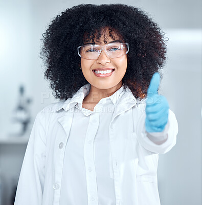 Buy stock photo Portrait of a beautiful young african american woman with an afro wearing a labcoat and gloves while giving thumbs up and standing in her laboratory. A mixed race female scientist wearing goggles