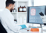 One mixed race scientist from the back analysing medical test samples and data from microbiology and genetic research on computer screen in lab. Young man developing cure for virus with biotechnology
