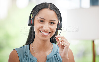 Close Up of a young smiling mixed race call centre agent talking to customers with a wireless technology headset. Hispanic businesswoman answering calls, helping clients from an office. Headshot of a female customer service representative