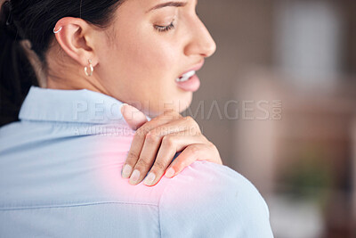 Closeup of young mixed race businesswoman standing alone and suffering from sore shoulder with CGI while working in an office. Hispanic professional in pain while holding an injury. Injured on the job