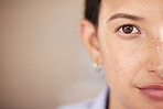 Closeup of mixed race woman's eye and face with freckles split in half looking straight ahead at the camera. One female only staring in front of her. Confident woman focused on her goals and vision 