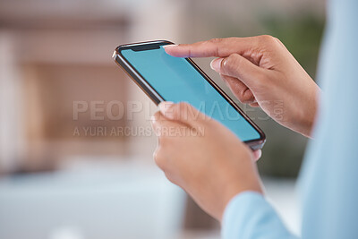 Unrecognizable businessperson holding and working on a phone in their hand while standing in an office at work. Unrecognizable person typing a message and using social media showing their screen