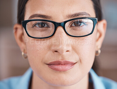 Closeup portrait of face of a serious businesswoman. Focused hispanic business professional wearing spectacles standing in her office. Powerful, leading single female only in her workplace. Face of a beautiful woman