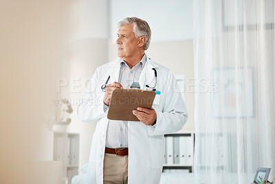 Buy stock photo Pensive mature male caucasian doctor in white lab coat looking out window, thinking or pondering. One senior man holding a clipboard with patient records while looking thoughtful