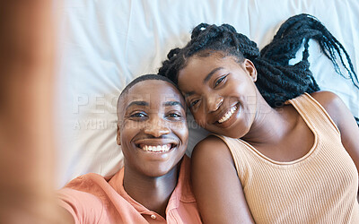 Buy stock photo Closeup of happy african american couple taking a selfie while lying on their together. Young carefree couple relaxing in their bedroom and spending time together