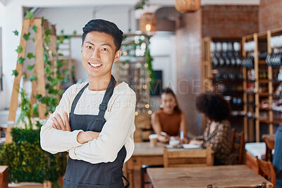 Buy stock photo Portrait of one smiling handsome asian business owner standing with his arms crossed in his cafe. Confident and successful mixed race man wearing an apron in his restaurant. Ambitious entrepreneur