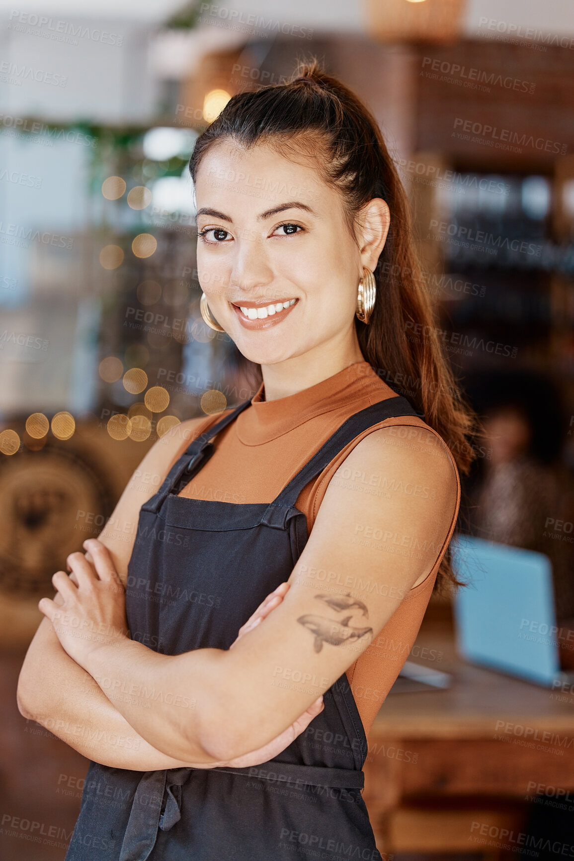 Buy stock photo Portrait of one smiling beautiful asian business owner standing with her arms crossed in her cafe. Confident and successful mixed race woman wearing an apron in her restaurant. Ambitious entrepreneur