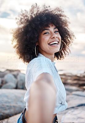 Buy stock photo A young mixed race woman smiling on the beach while reaching out her hand. Happy hispanic female with a cool afro hairstyle outdoors