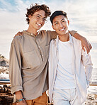 Portrait of two attractive young men standing together on the beach. Asian male and his best friend embracing one another on a day out with friends