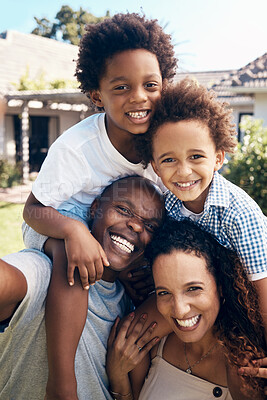 Happy african american family of four having fun while taking selfies in the sun. Carefree parents carrying sons for piggyback rides while bonding outside. Mom and dad enjoying quality time with kids