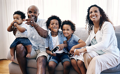Buy stock photo Sibling brothers playing video games together while sitting with their family. African american family of five having fun and spending time together. Mom and dad cheering their sons on while playing 