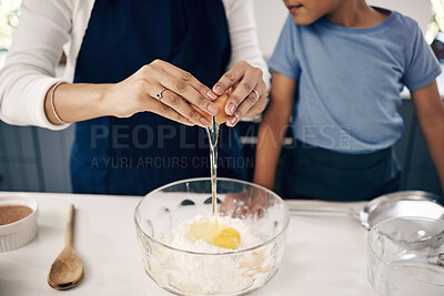 Buy stock photo Closeup of female hands cracking a egg into a bowl while baking at home with her son. Woman adding ingredients to a glass bowl on the counter at home while baking with her child