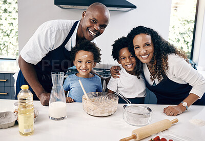 Buy stock photo Portrait of cheerful african american family baking together at home. Happy couple and their two sons having fun while mixing ingredients in their kitchen. Baking is a fun family bonding activity