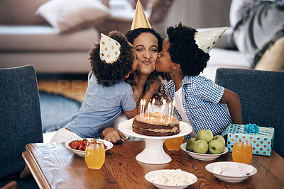 Buy stock photo Young cheerful mixed race female getting a kiss on the cheek from her two little sons on her birthday during a party while wearing hats inside a lounge. Two african american boys showing affection to their mother