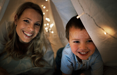 Portrait of caucasian Happy family, mother and young son playing and smiling in a blanket tent in the even evening in the dark