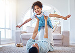 Adorable smiling mixed race girl bonding with her single father in a home living room. Hispanic man playing games and lifting his daughter into the air. Happy child enjoying a weekend with her parent