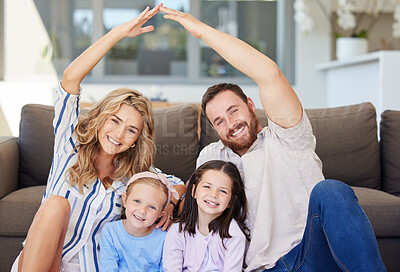 Buy stock photo Smiling couple with little kids sitting and making symbolic roof with hands over children. Cheerful family sitting together on floor in new house on relocation day. Covered and protected by insurance