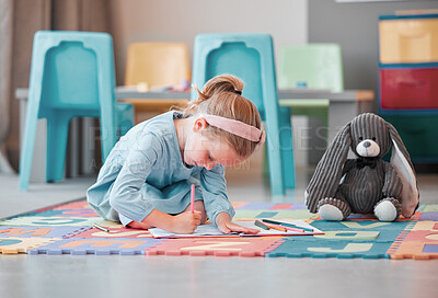 Buy stock photo Cute preschool little girl colouring with pencils in a book alone in school. Caucasian child enjoying drawing with her favourite stuffed animal and best friend. Curious small kid engaged in creativity