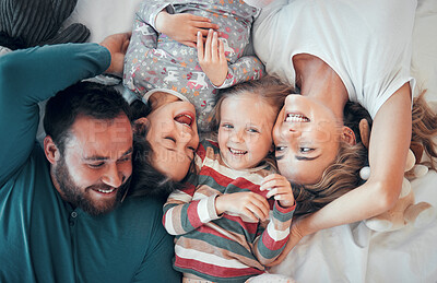 Buy stock photo Young caucasian family of four bonding while relaxing in bed together. Young cheerful couple having fun with their two adorable young daughters and taking selfies in bed 
